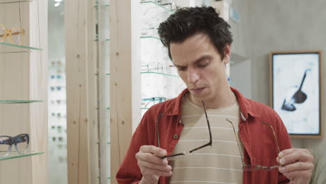 man trying on glasses in an optical shop