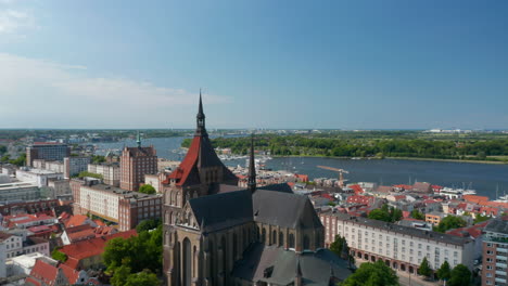 Fliegen-Sie-Nach-Vorne-über-Die-Saint-Mary-Church-In-Richtung-Sea-Bay-Waterfront.-Mittelalterliche-Gotische-Backsteinbasilika