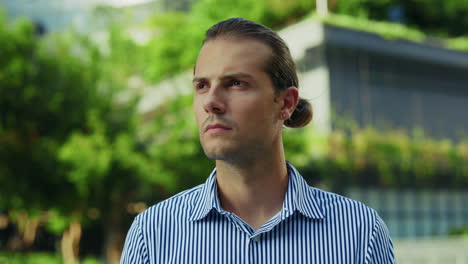 close-up portrait of a serious man looking at the camera outdoors