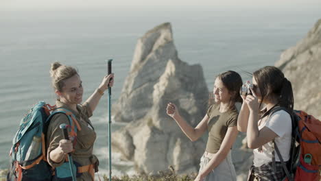 Girls-taking-photo-of-their-mother-on-hiking-trip-in-mountains