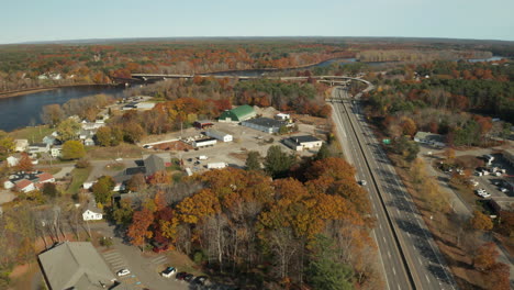 Maine-Route-1-Aerial-autumn-shot-of-highway-exiting-a-town-along-river-banks