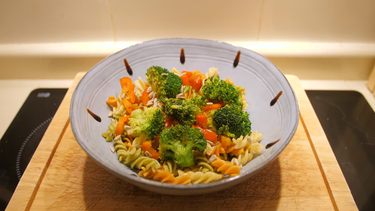 부엌에 있는 나무 테이블에 발사믹 식초 방울과 후추와 함께 브로콜리로 요리한 오리지널 셰프 파스타 요리의 높은 각도