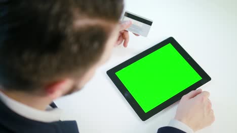 a young man using a tablet with a green screen
