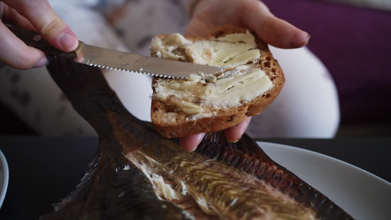 persona haciendo un delicioso sándwich de pescado fresco con un cuchillo de cocina, de cerca