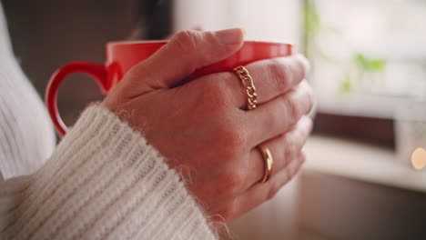 Manos-De-Mujer-Sosteniendo-Una-Gran-Taza-Naranja-De-Té