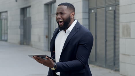 Businessman-looking-on-tablet-screen-on-street.-Afro-man-using-pad-outdoor