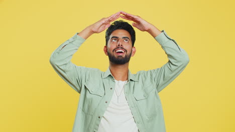 Indian-man-feeling-in-safe-making-roof-above-head-with-hands-insurance-security-service-playing-game