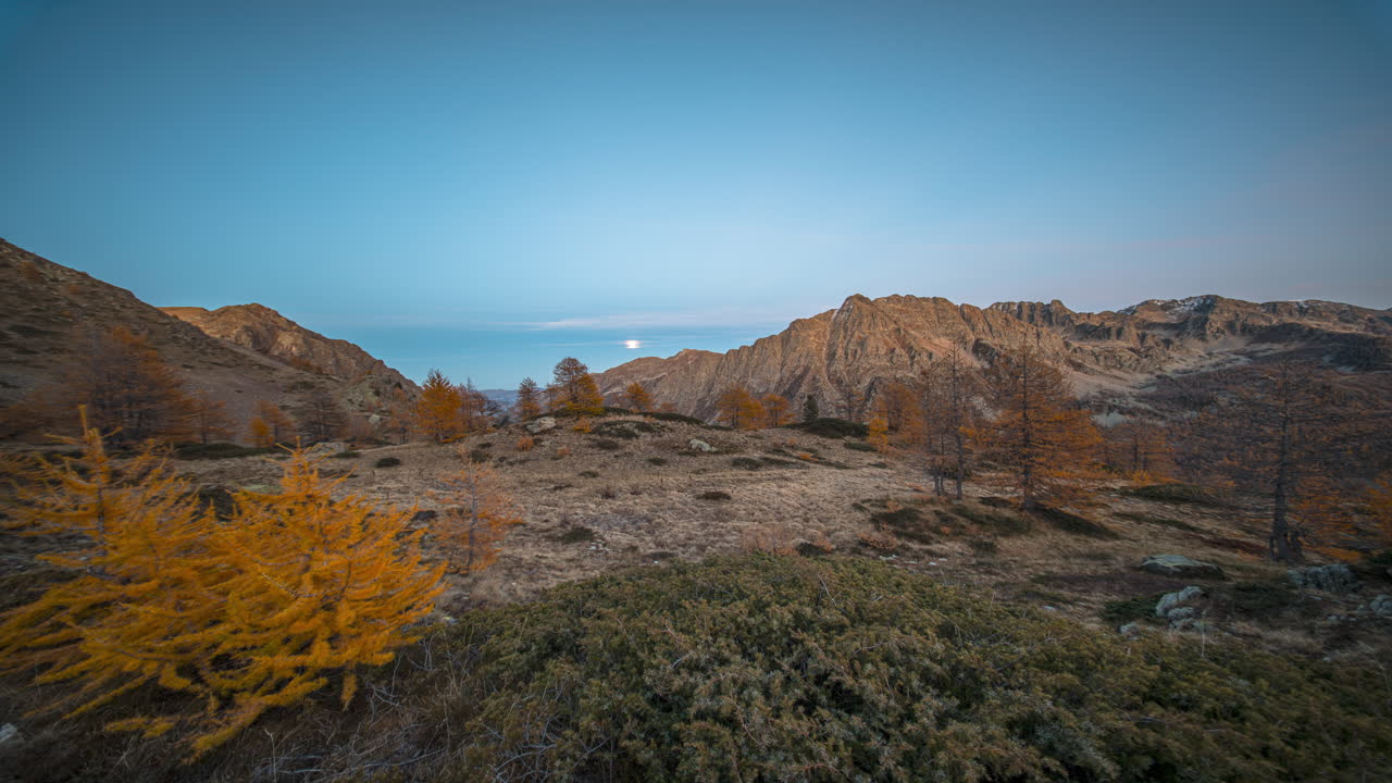 Colle della Lombarda autumn scene with mountains, trees in a timelapse