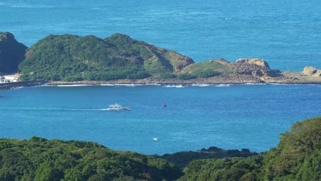 Landscape-views-of-a-boat-sailing-on-the-waterway-of-Shen'ao-fishing-harbor,-views-from-Jiufen-Old-Street-mountain-town,-Ruifang-district,-New-Taipei-City,-Taiwan