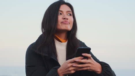 una chica asiática usando un teléfono móvil.