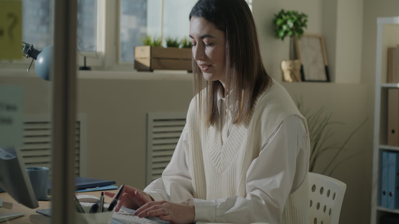 mujer trabajando en computadora en una oficina moderna