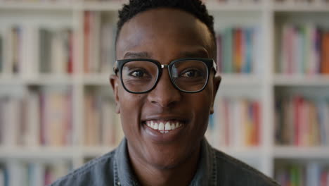 Porträt-Eines-Glücklichen-Jungen-Afroamerikanischen-Studenten,-Der-Lächelt-Und-Einen-Erfolgreichen-Lebensstil-Genießt.-Intelligenter-Schwarzer-Mann,-Der-Fröhlich-Aussieht-Und-Eine-Brille-Im-Bücherregal-Hintergrund-In-Zeitlupe-Trägt
