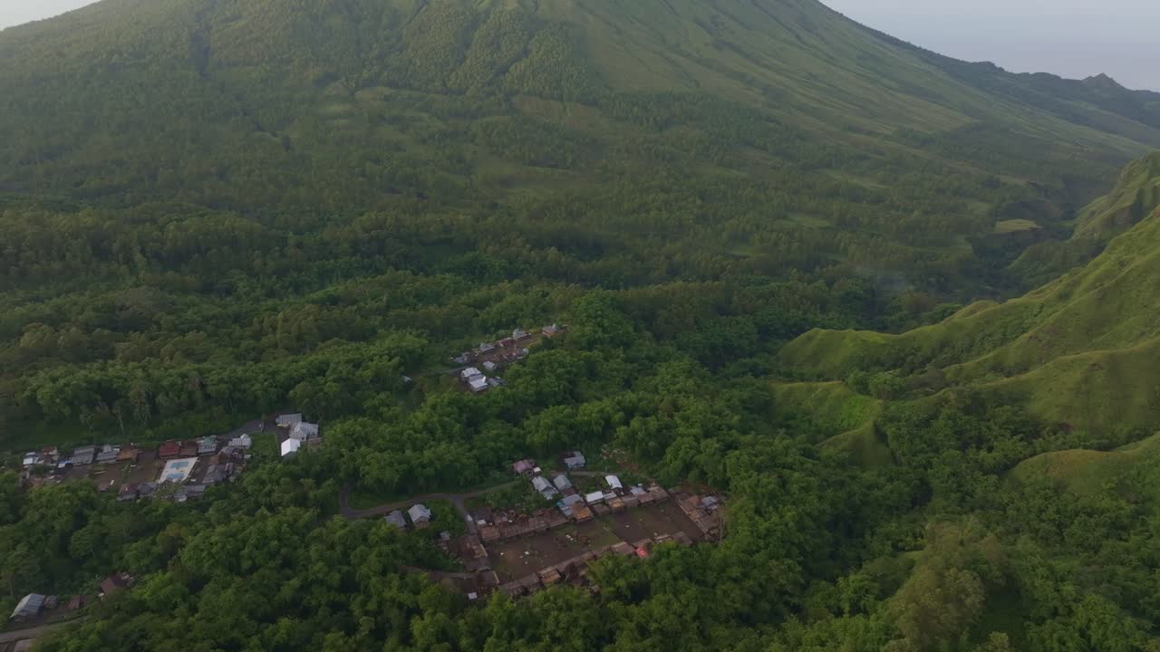 Tepi desa tradisional berbatasan dengan hutan lebat di bawah Gunung Inerie, Flores, Indonesia