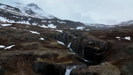 pintoresca cascada klifbrekkufossar en el este de islandia - retroceso aéreo