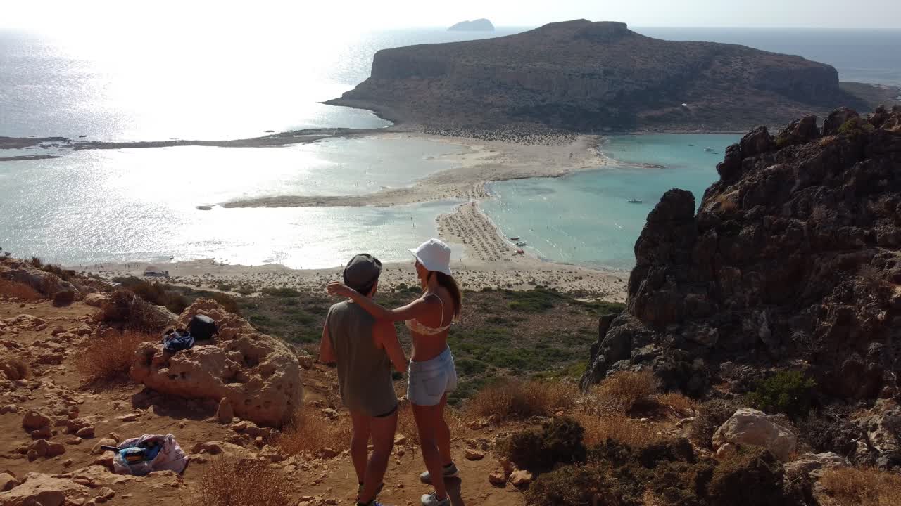 una pareja feliz disfrutando de las vacaciones en la playa de la laguna de gramvousa y balos, grecia