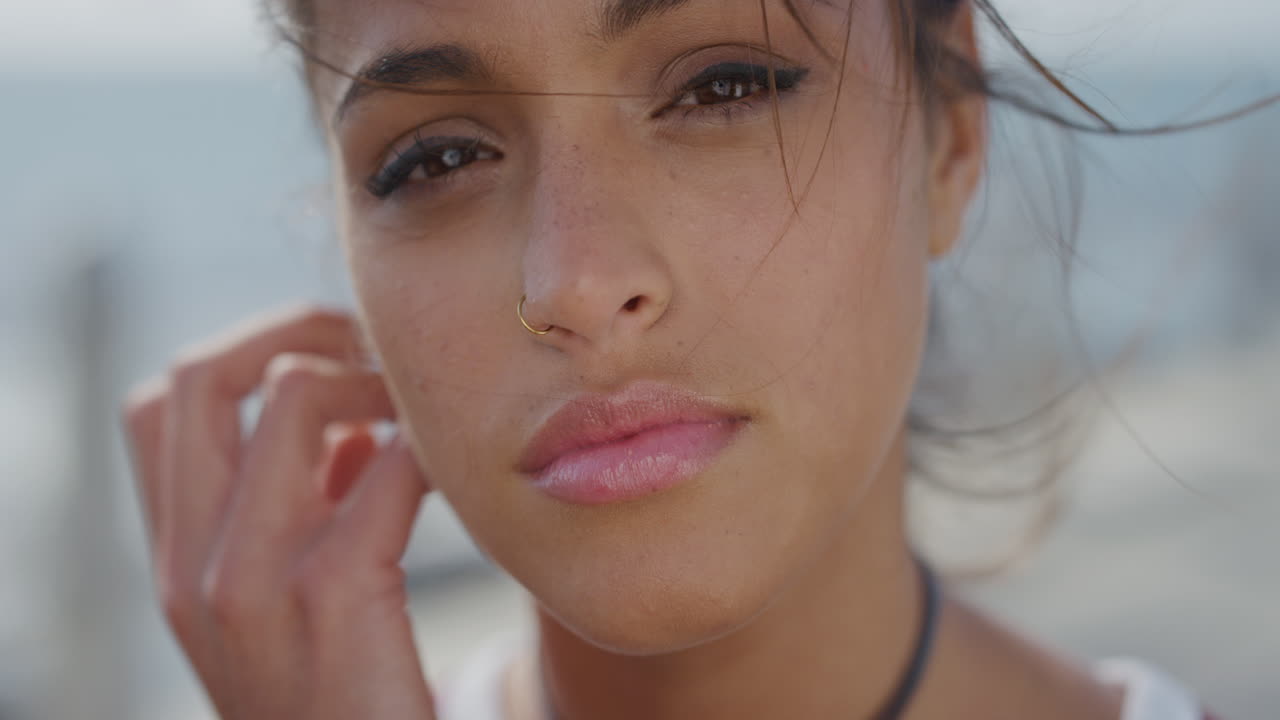 retrato de cerca hermosa joven mujer hispana con aspecto tranquilo corriendo mano a través del cabello soplando el viento mujer atractiva piel perfecta sana belleza femenina cámara lenta