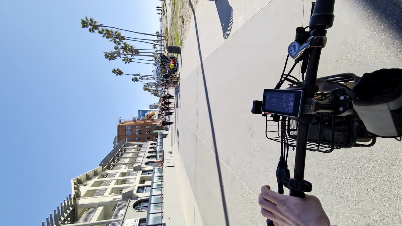 Riding an e-bike along a sunny coastal boardwalk
