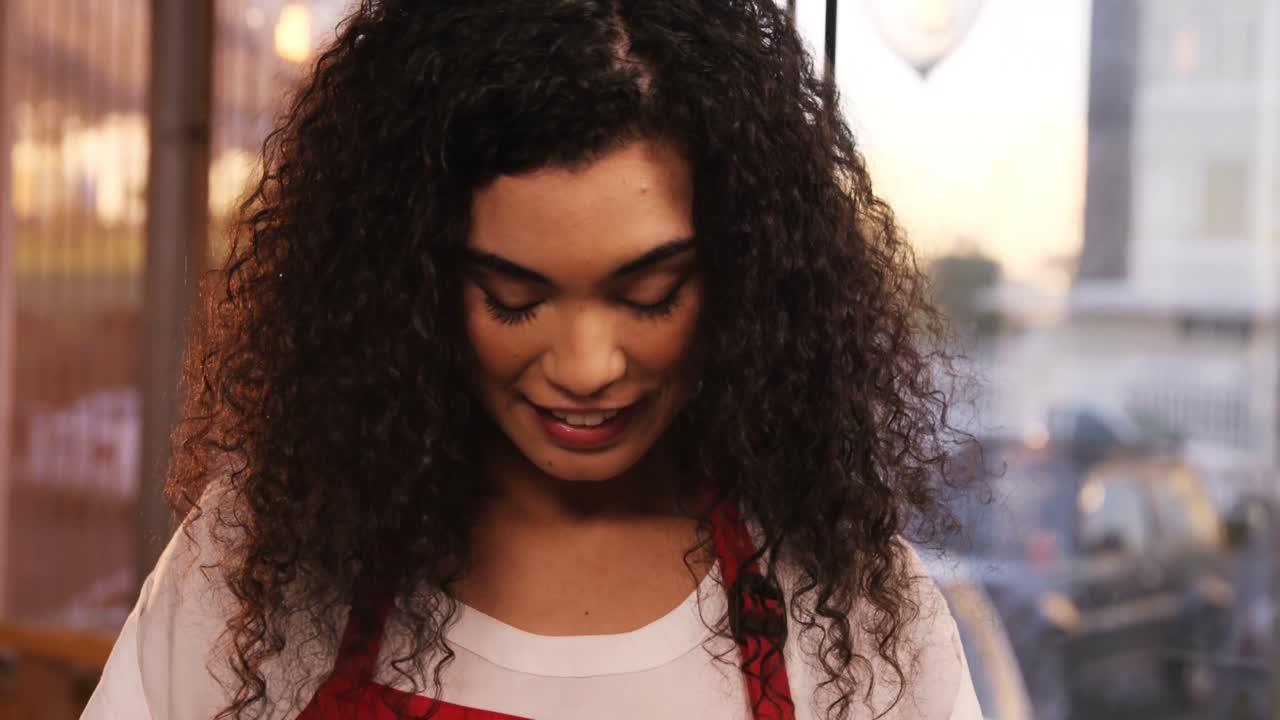 camarera sonriente mostrando pizarra con un letrero abierto