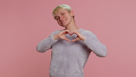 smiling pretty woman makes heart gesture demonstrates love sign expresses good feelings and sympathy