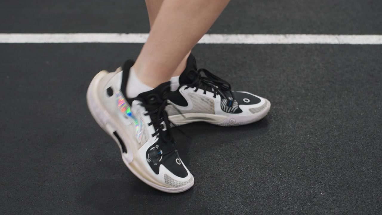 Gioco di gambe veloce sul campo. Scarpe agili sulla superficie di gioco. Concentrazione su rapidi passi laterali durante gli esercizi sul campo. Primo piano di calzature atletiche che dimostrano rapidi movimenti laterali sulla superficie del campo.