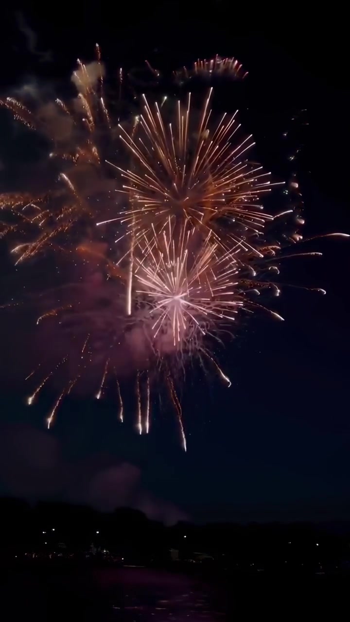 Vibrant Fireworks Exploding in the Night Sky Above Water