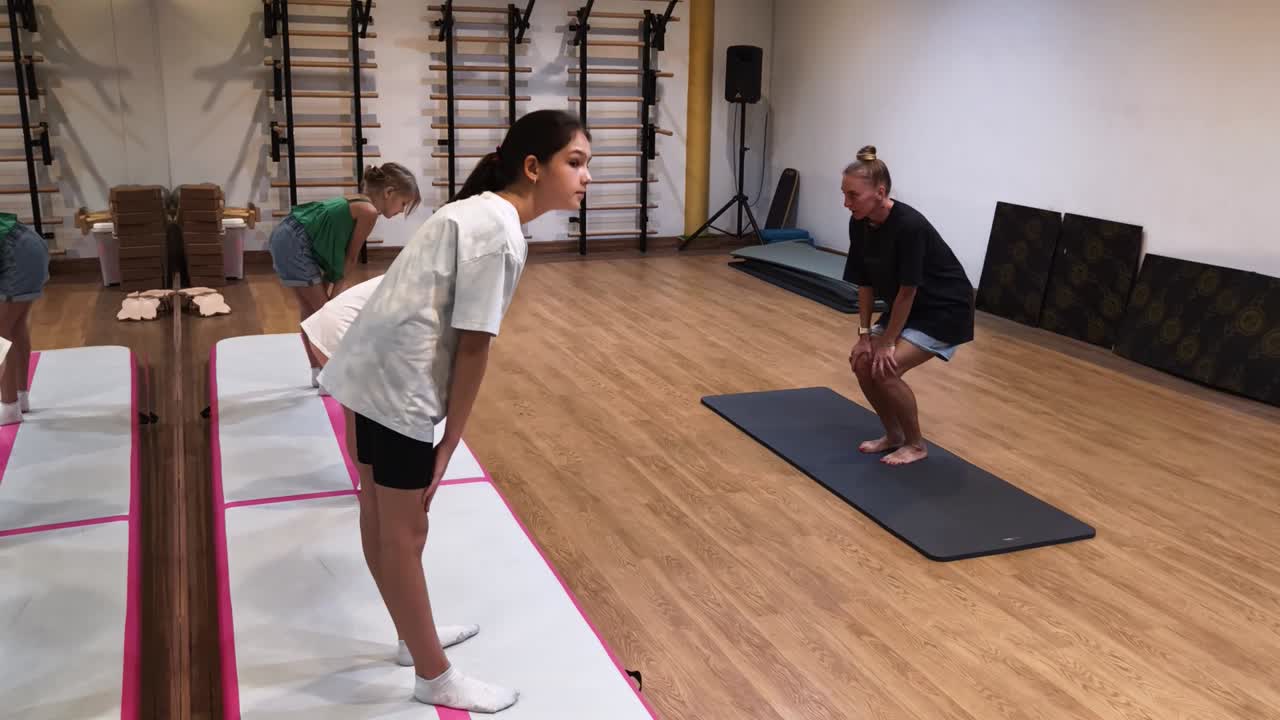 niños y mujeres haciendo ejercicios de yoga en un gimnasio
