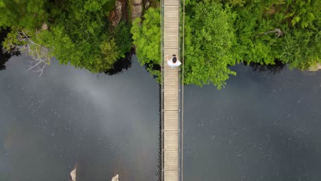 Vista-Aérea-Sobre-Un-Puente-En-Medio-Del-Río,-En-Un-Parque-En-Europa