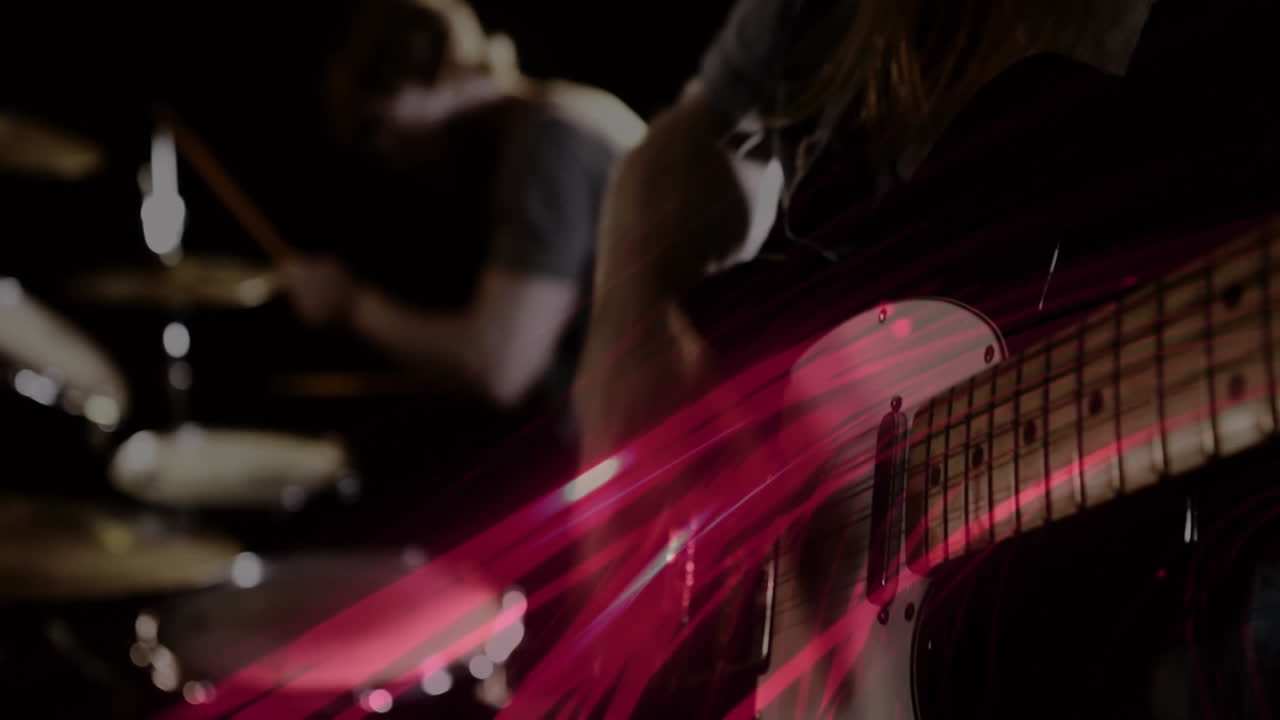 Male guitarist and drummer performing on stage, displaying animated red streaks for music industry
