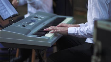 primer plano de alguien tocando el piano durante una fiesta de bodas