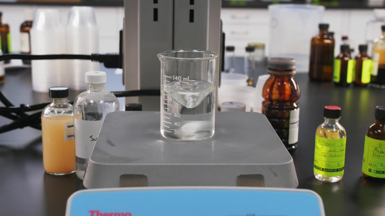 establecimiento de una toma de máquina en un laboratorio de ciencias probando productos químicos en una botella de vidrio transparente