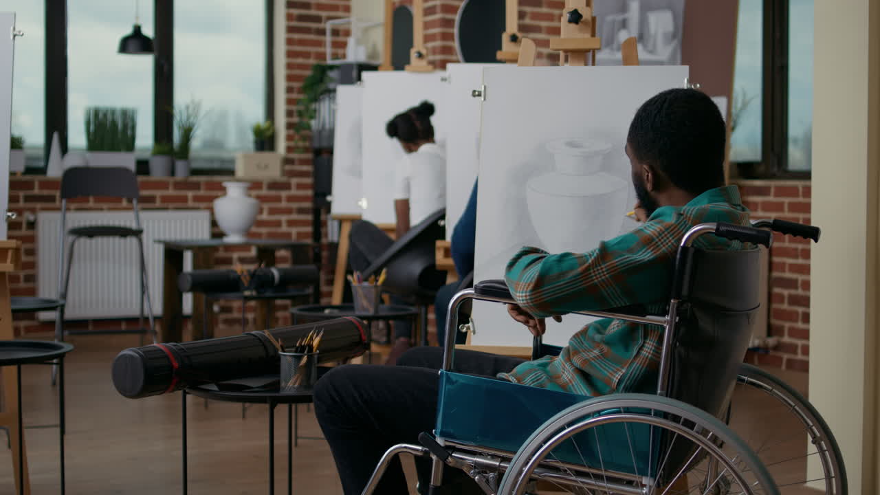 Young man in wheelchair drawing masterpiece with pencil