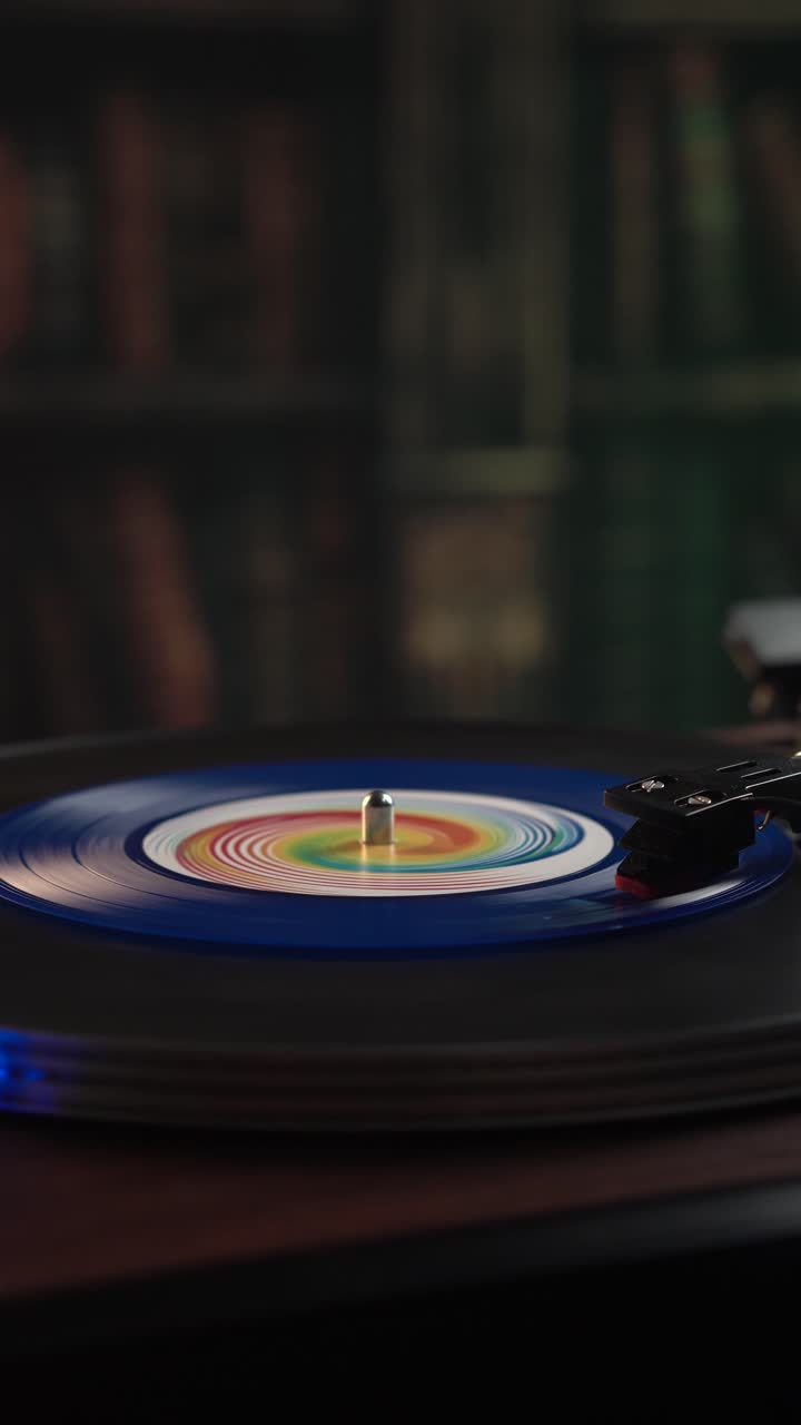 Vista verticale, riproduzione di un disco in vinile blu su giradischi vintage in biblioteca