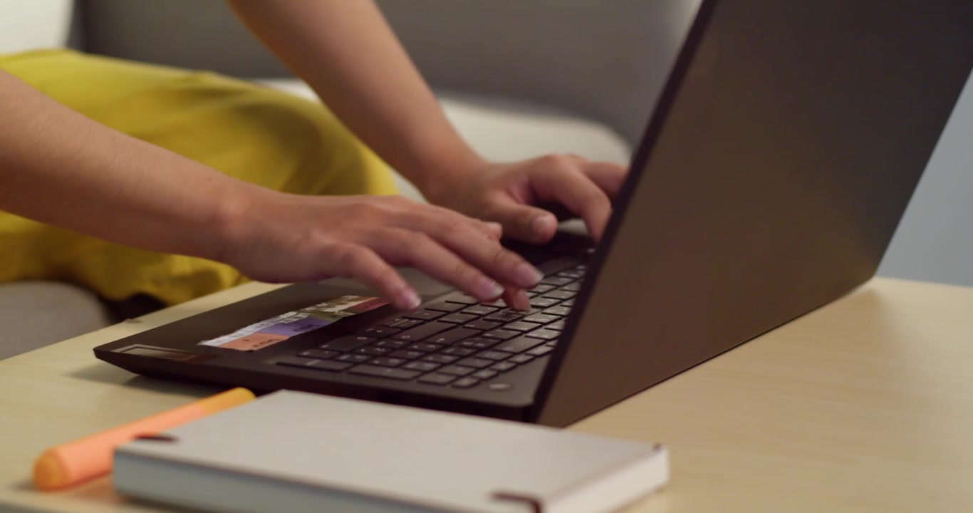 En person, der hurtigt taster på en bærbar computer på en hyggelig arbejdsplads, der viser produktivitet og teknologisk engagement.
