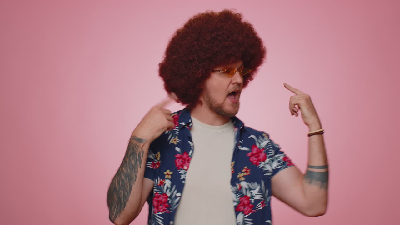 hombre gracioso escuchando música, sonriendo bailando a la música discoteca de la fiesta moviendo rítmicamente las manos divirtiéndose