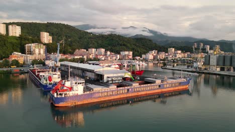 a video that captures the enchanting reflection of the lights of the ships waiting in the harbor as they dance on the sea surface at sunset