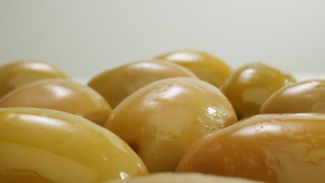 aceitunas verdes redondas en vinagre de grecia como fondo, vista de arriba. imágenes de alta calidad en 4k