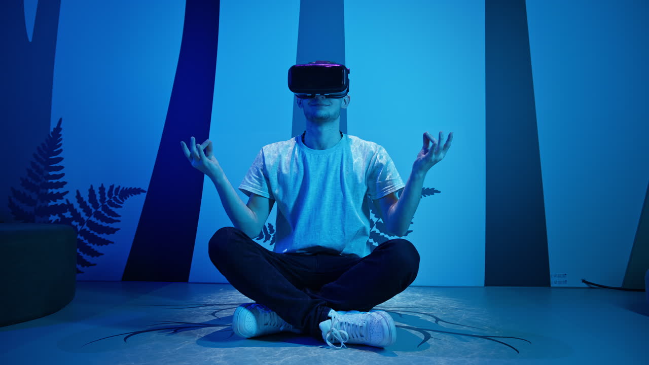 Man with VR glasses sitting on the virtual reality escape room floor, handheld