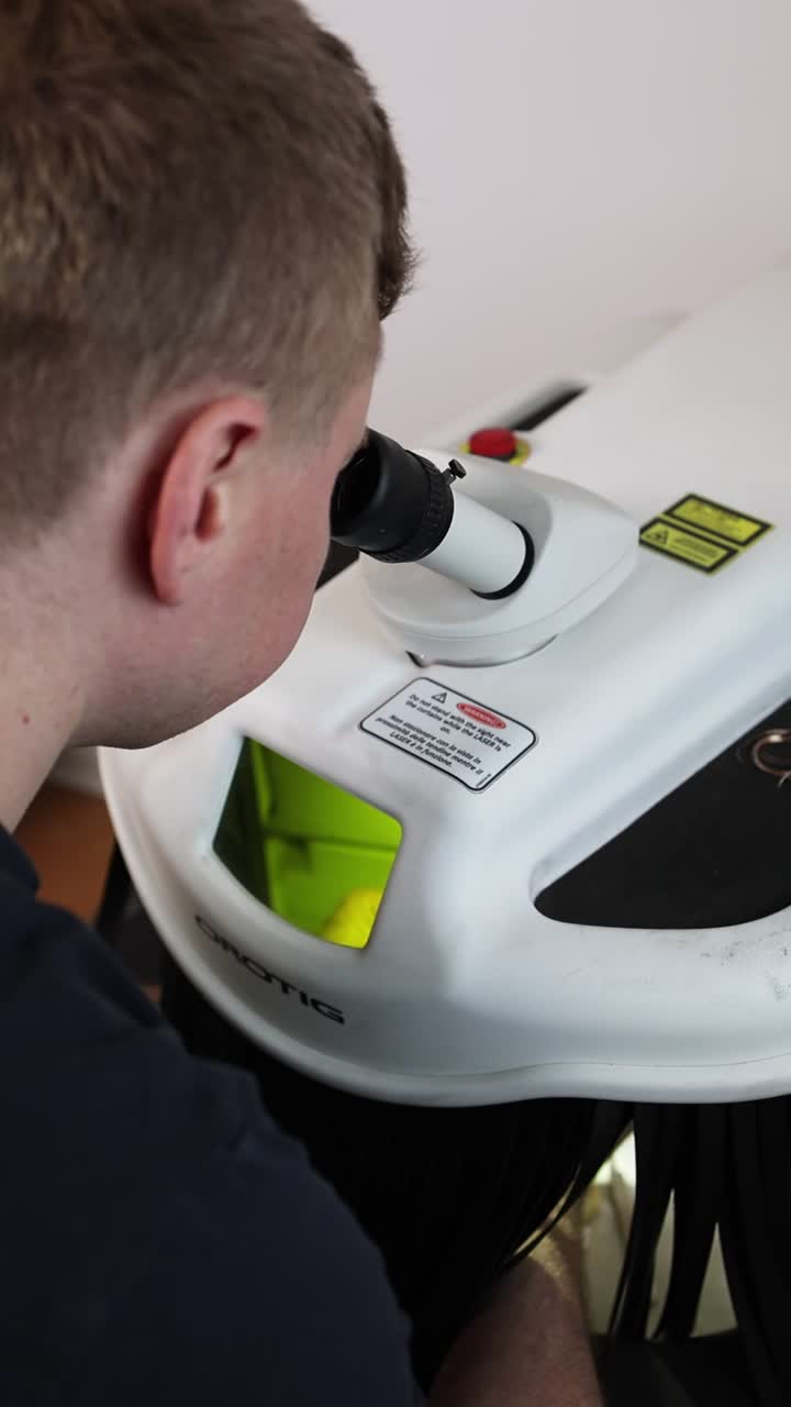 Man Looking Through a Microscope in a Laboratory