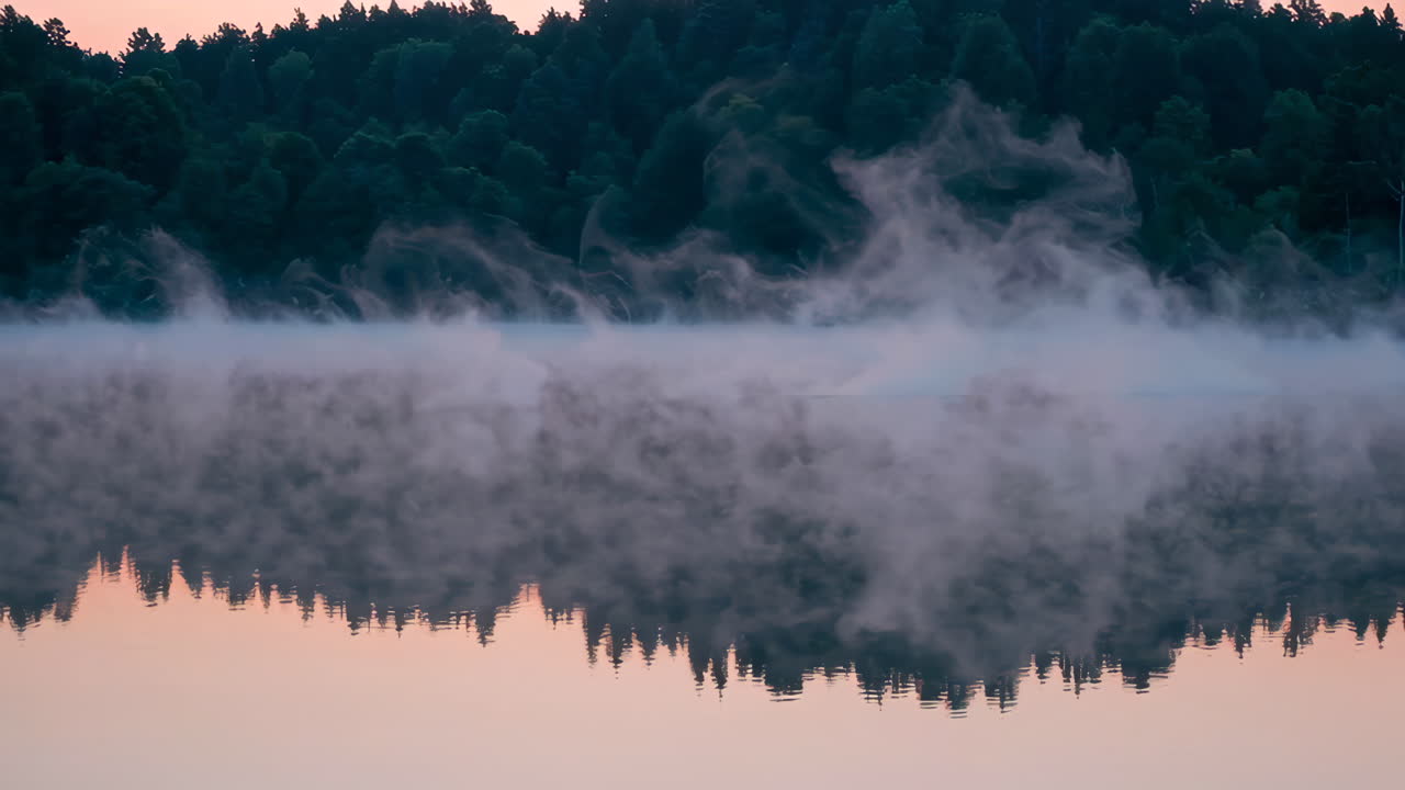 Misty Sunrise over a Calm Lake with Forest Reflection