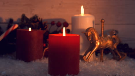 view of big candles burning next to christmas decorations