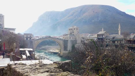 view of old town and old bridge in mostar with a mountainous background