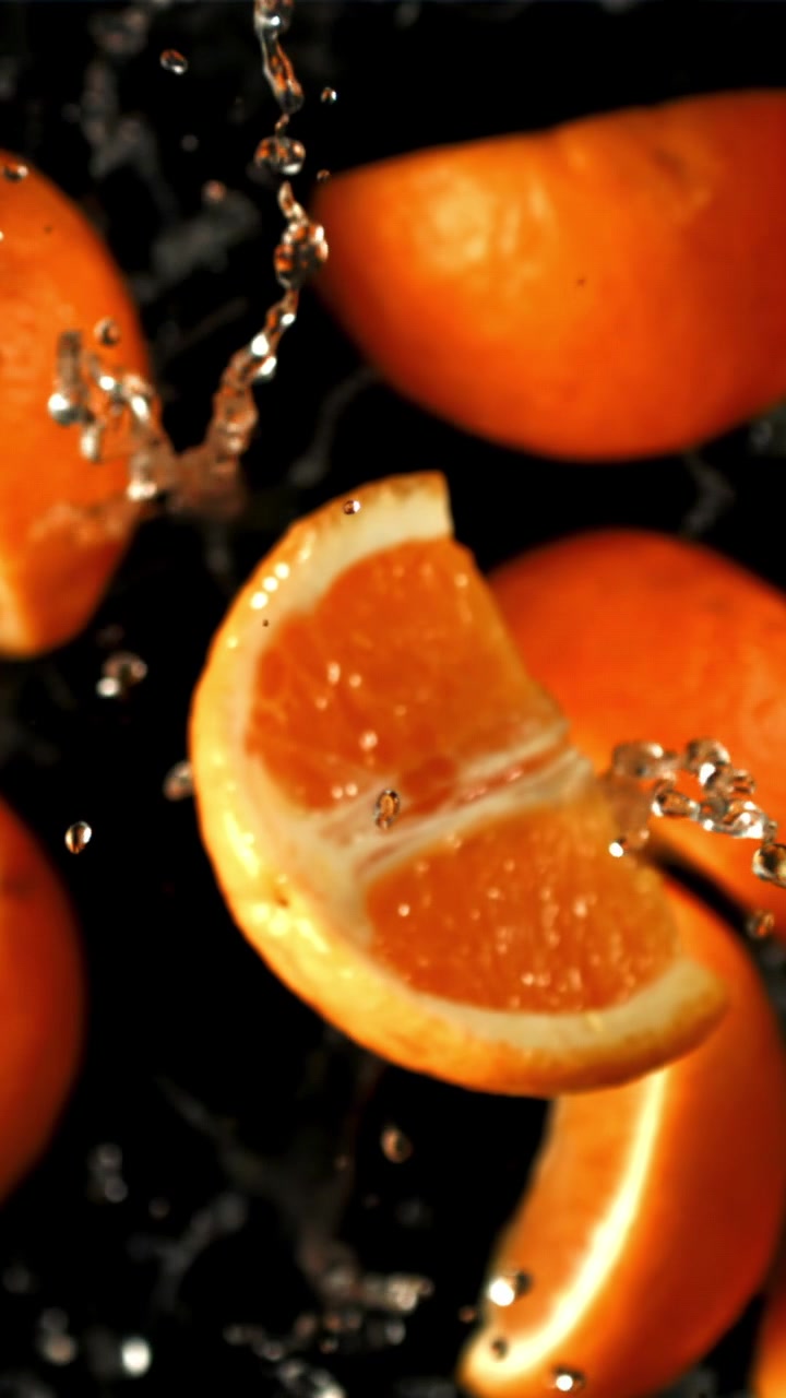 Fette d'arancia fresche con schizzi d'acqua al rallentatore