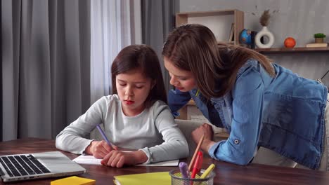 sister helping her little sister with homework