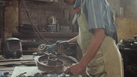 blacksmith using cutting wheel in workshop