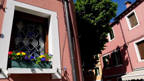 vibrant windows of colorful venetian buildings with flower boxes