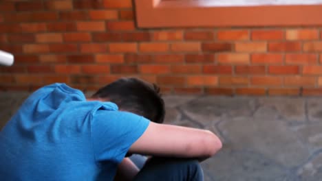 Schoolboy-sitting-in-school-premises