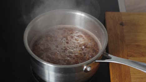 Kochen-Von-Buchweizen-In-Metalltopf-Auf-Heißem-Dampfwasser,-Statische-Ansicht