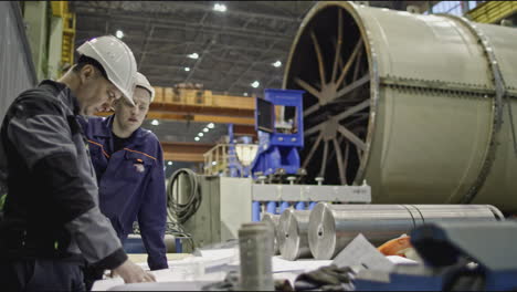 factory workers reviewing plans