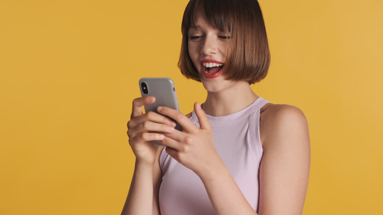 Cheerful woman using gray smartphone