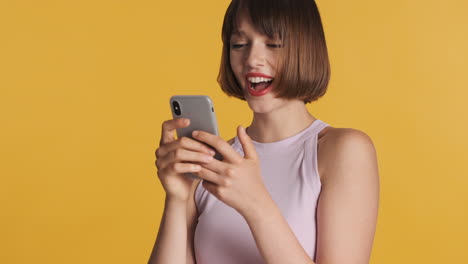 cheerful woman using gray smartphone